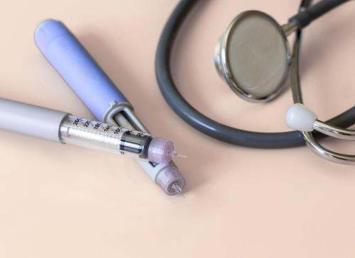 Injectable medicine next to a stethoscope