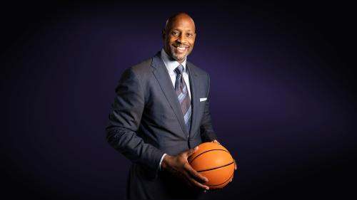 Alonzo Mourning headshot in a suit holding a basketball