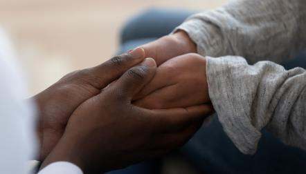Closeup of adult holding child's hands 