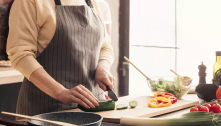 Person cutting vegetables in a kitchen