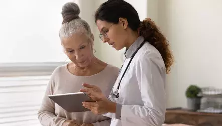 A doctor talking to an elderly female patient