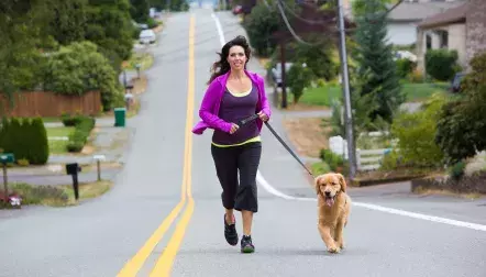 woman runs with dog