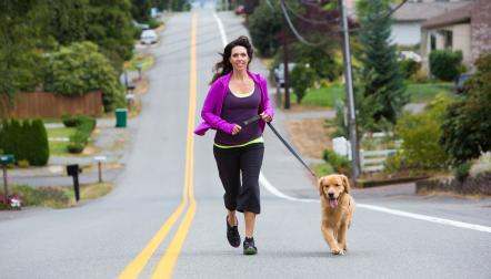 woman runs with dog