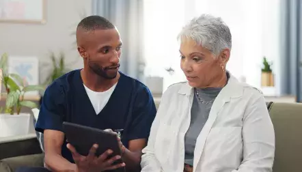 A nurse talking to an elderly patient