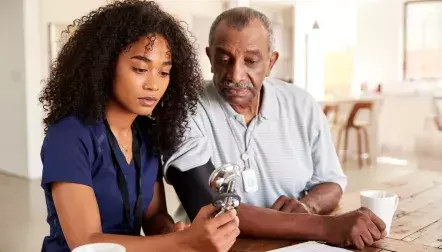 A nurse checking the high blood pressure of an older man