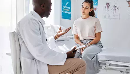A doctor talking to a young female patient