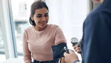 A woman getting her blood pressure checked by a doctor