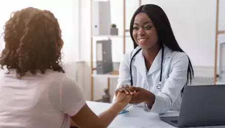 Female doctor holding a patients hand