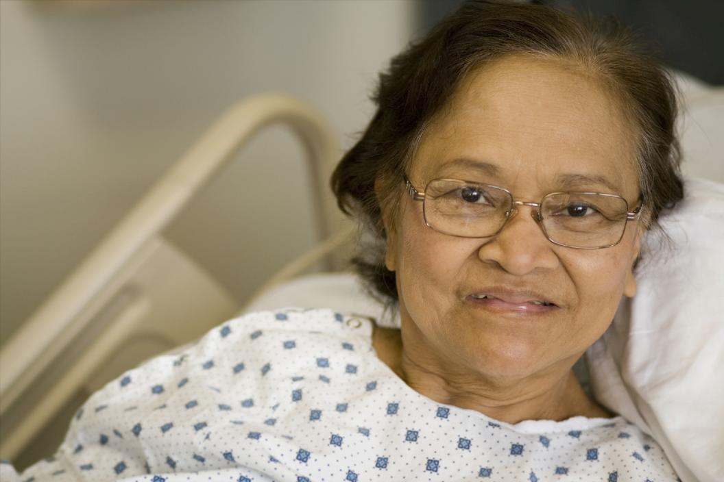 hispanic senior woman in hospital gown