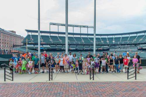 A group of adults and children in Camden Yards Stadium