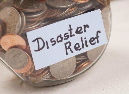 Glass jar with coins with "Disaster Relief" written on it