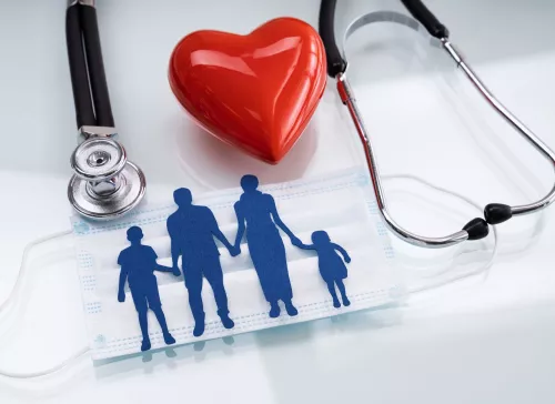 Silhouettes of family holding hand with stethoscope and heart