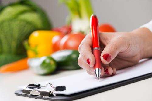 nutritionist writing food in background shutterstock 248483716  1
