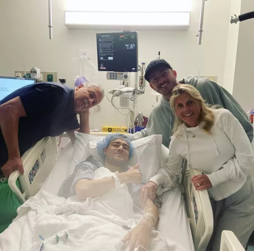 Jackie Medici's brother in a hospital bed with family standing around him