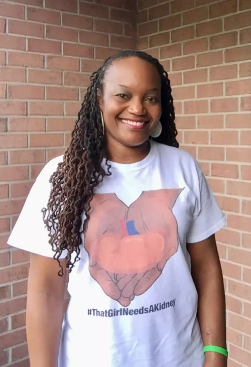 Malkia White in a white t-shirt that says "#ThatGirlNeedsAKidney"