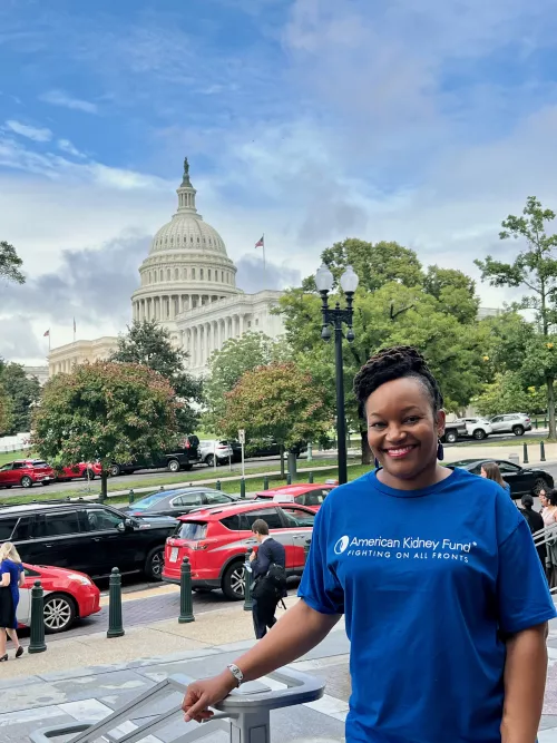 Malkia White in an AKF blue t-shirt standing in front of the U.S. Capitol