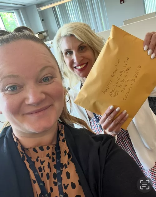 Tracey Previti holding up a large envelope for her grant application