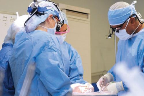 four surgeons operating