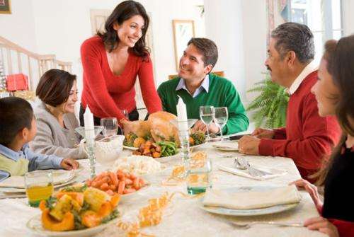 A family of six sitting around a festive thanksgiving meal