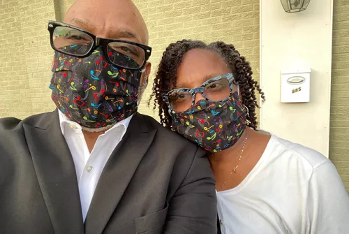 black man and black woman with glasses and face masks taking a selfie