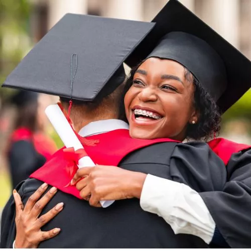 African American teen graduates and hugs