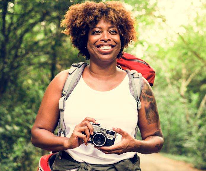 black woman hiking with camera shutterstock 1107463031  1