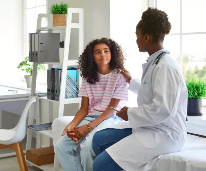 A female doctor talking to a young female patient