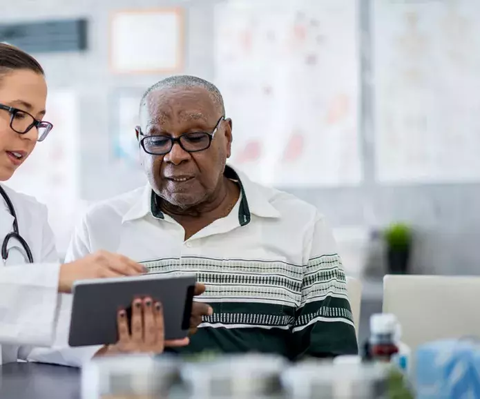 nurse with black senior at tablet