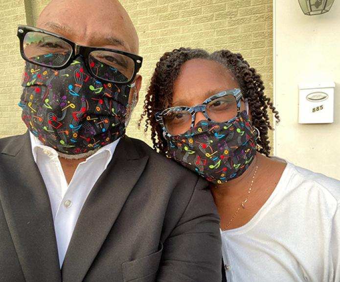 black man and black woman with glasses and face masks taking a selfie