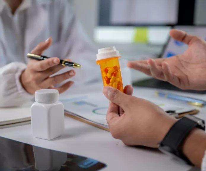 A doctor holding a prescription bottle