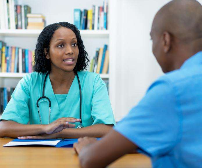 A young female doctor talking to a male patient