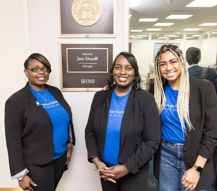 3 women standing in front of a senate office