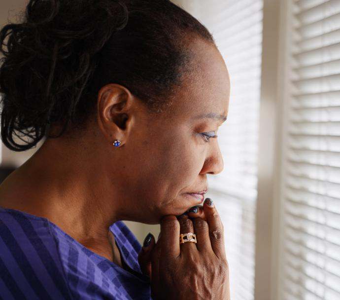 black senior woman worried at window