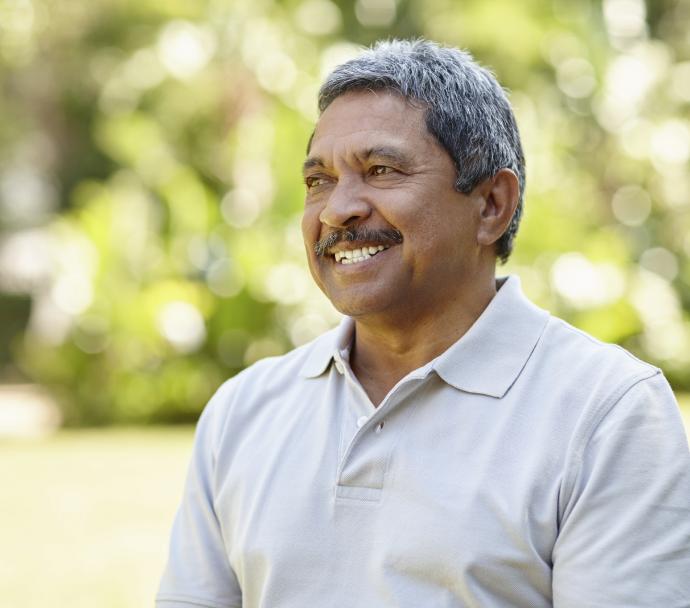 brown senior man smiling in park iStock 000062784216 Double