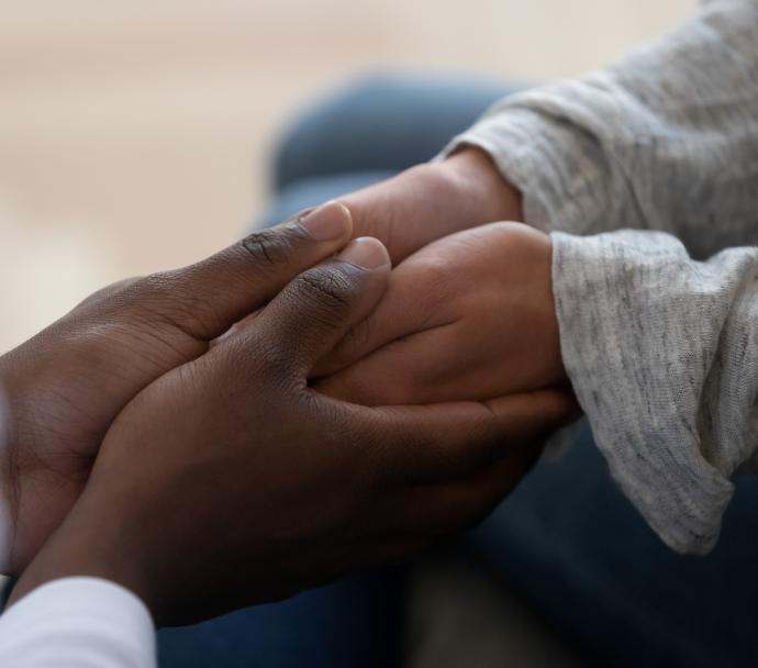 Closeup of adult holding child's hands 
