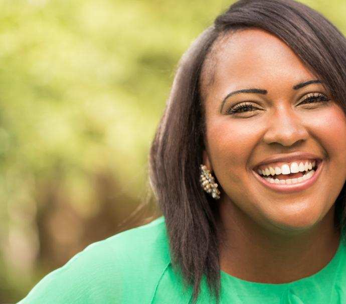 black woman smiling green shirt outside