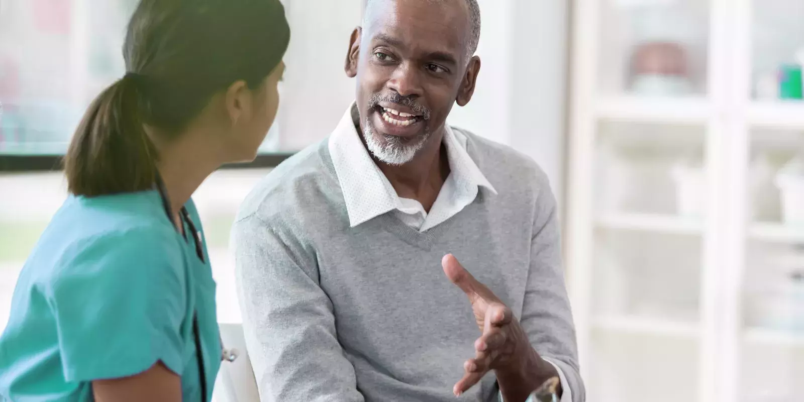 Black older male patient talking to a doctor