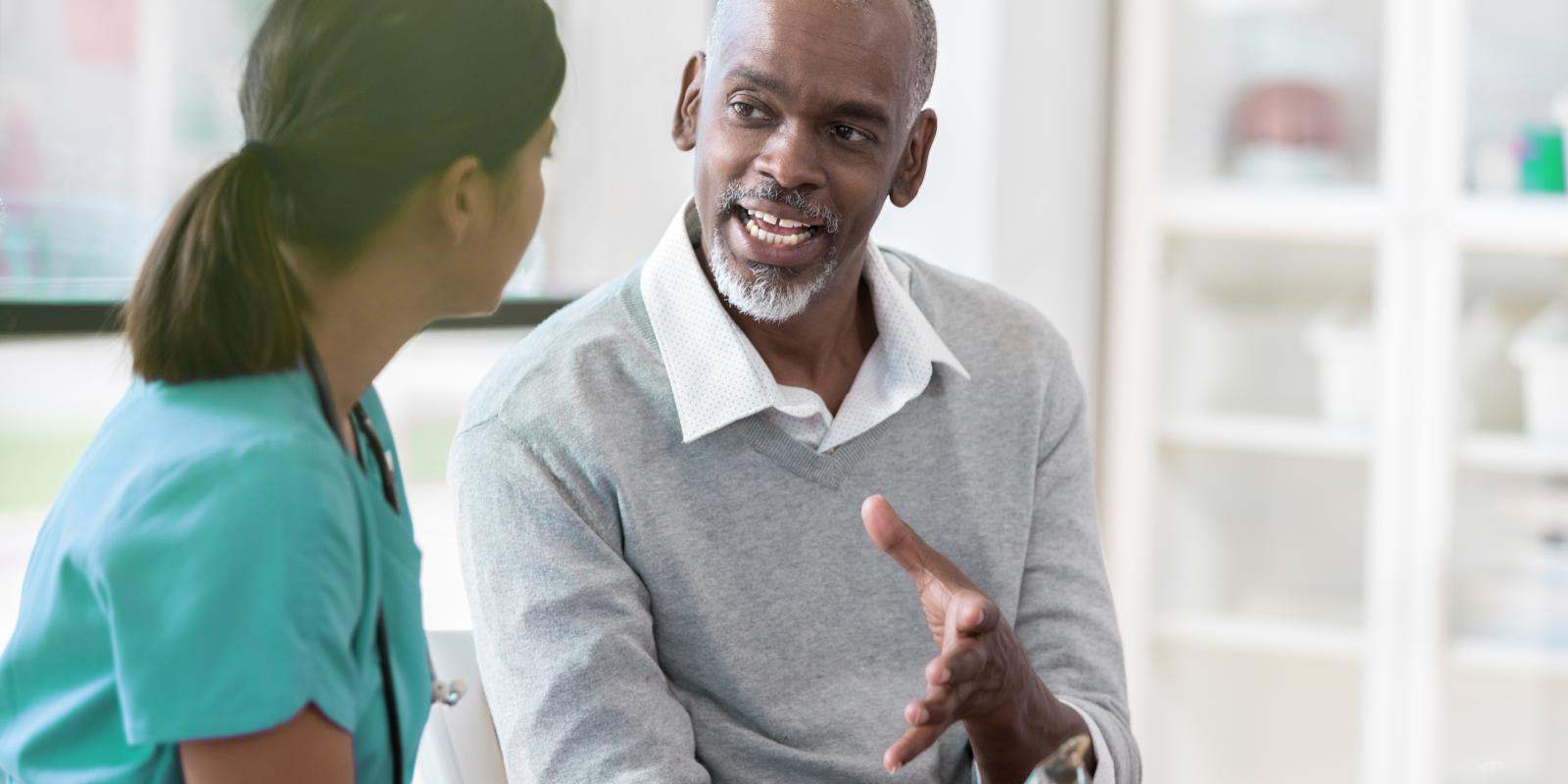 Black older male patient talking to a doctor