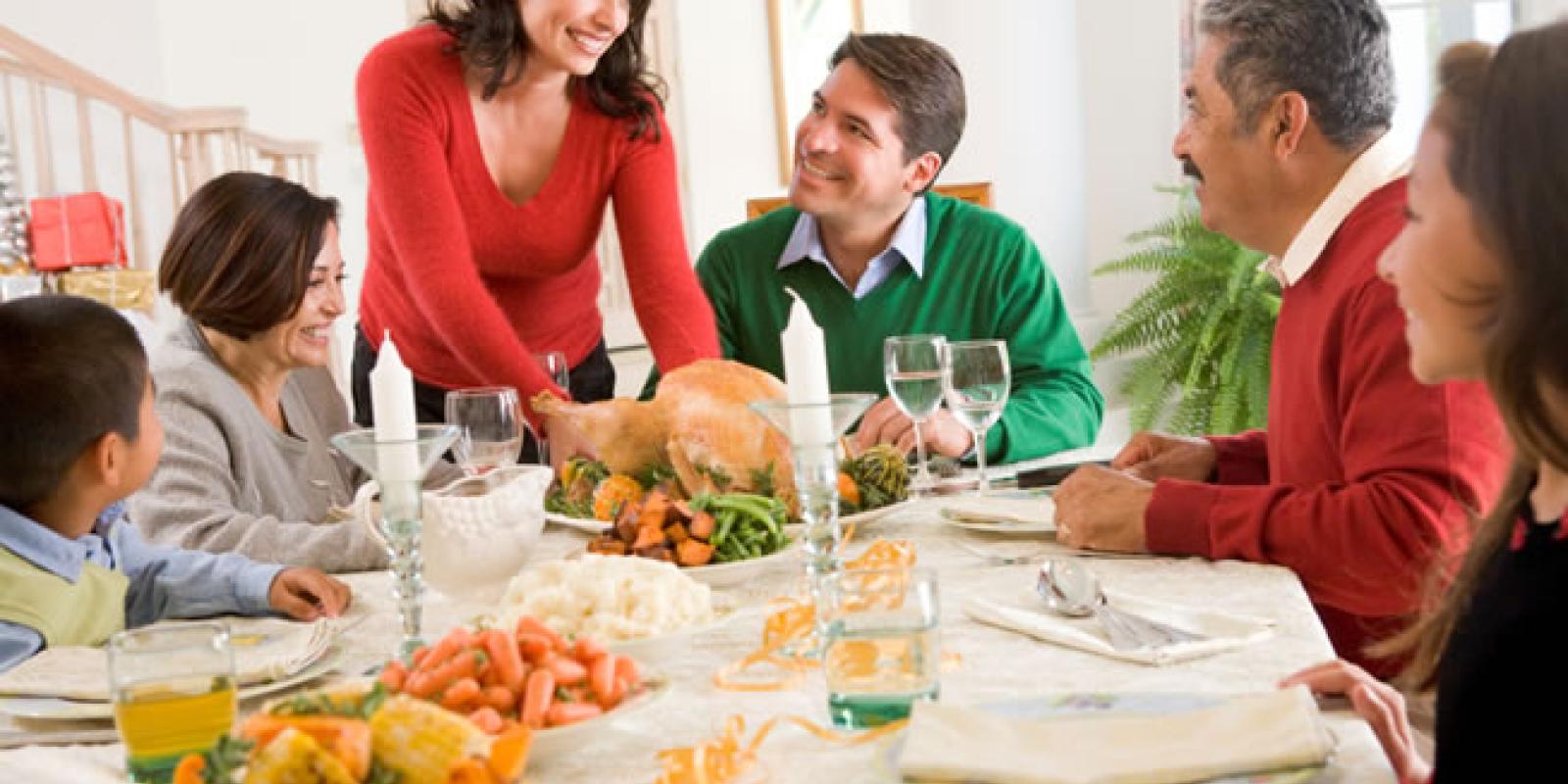 A family of six sitting around a festive thanksgiving meal