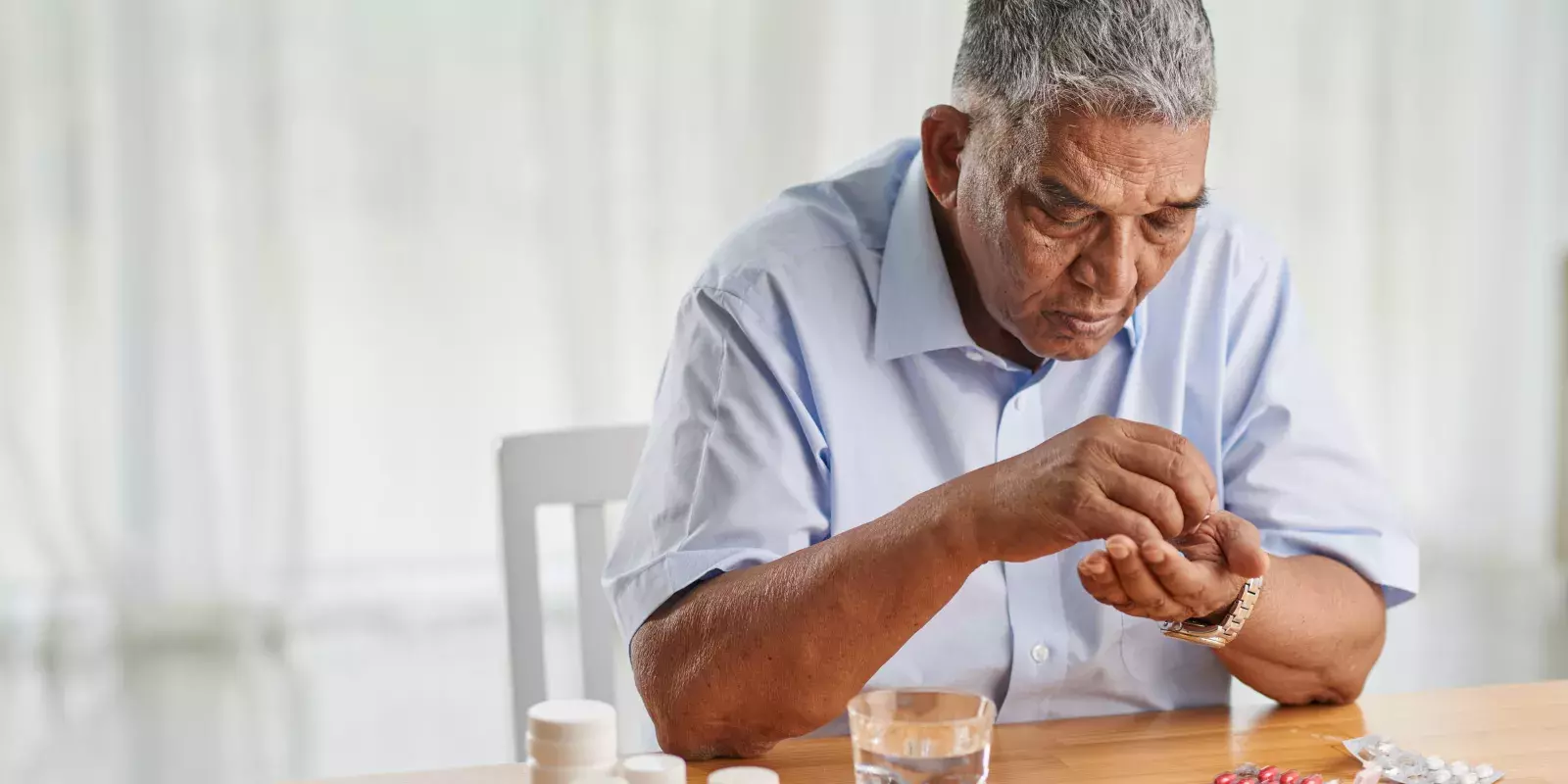 senior man counting pills