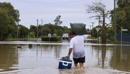 man carrying supplies in flood