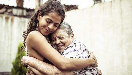 A young Hispanic woman hugging an older woman