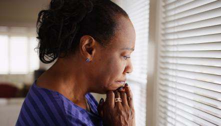 black senior woman worried at window