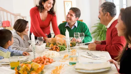 A family of six sitting around a festive thanksgiving meal