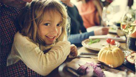 girl on dads lap dinner thanksgiving shutterstock 4941483311