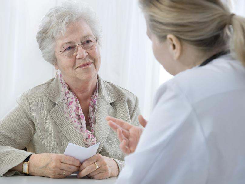 senior white woman listening to doctor